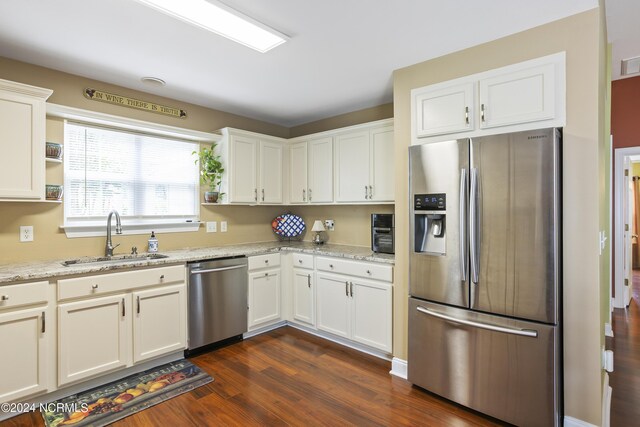 kitchen featuring dark wood finished floors, stainless steel appliances, visible vents, white cabinetry, and a sink