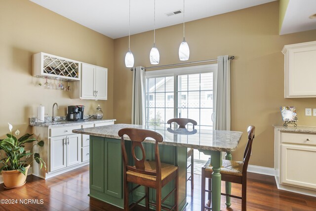 kitchen featuring baseboards, white cabinets, visible vents, dark wood finished floors, and light stone counters