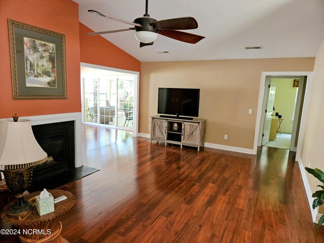 living room featuring lofted ceiling, visible vents, a fireplace, and wood finished floors