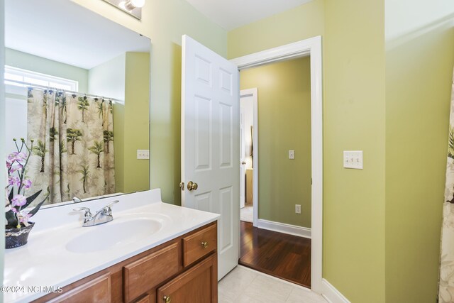 full bath featuring tile patterned floors, vanity, and baseboards