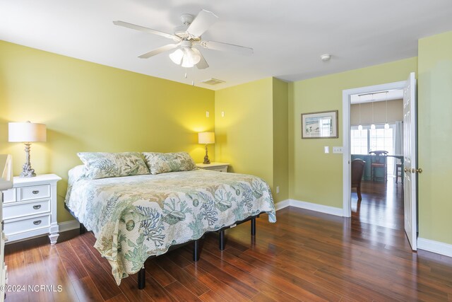 bedroom with visible vents, baseboards, and wood finished floors