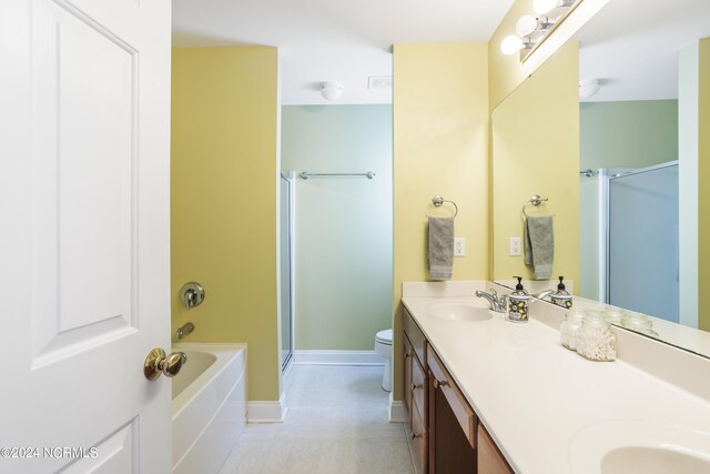 bathroom featuring double vanity, a shower stall, toilet, and a sink