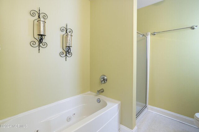 bathroom with toilet, baseboards, a shower with door, and a tub with jets