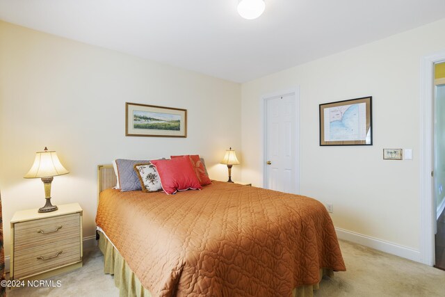 bedroom featuring light carpet and baseboards