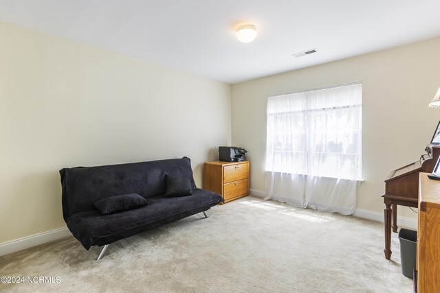 living area with baseboards, visible vents, and carpet flooring