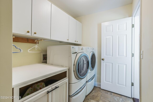 laundry room with independent washer and dryer and cabinet space