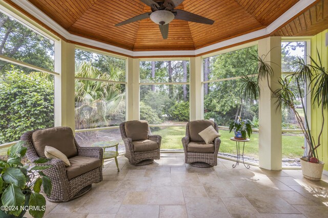 sunroom / solarium featuring wood ceiling and a ceiling fan