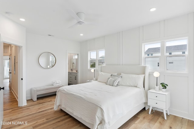 bedroom with ceiling fan, ensuite bathroom, and light hardwood / wood-style floors