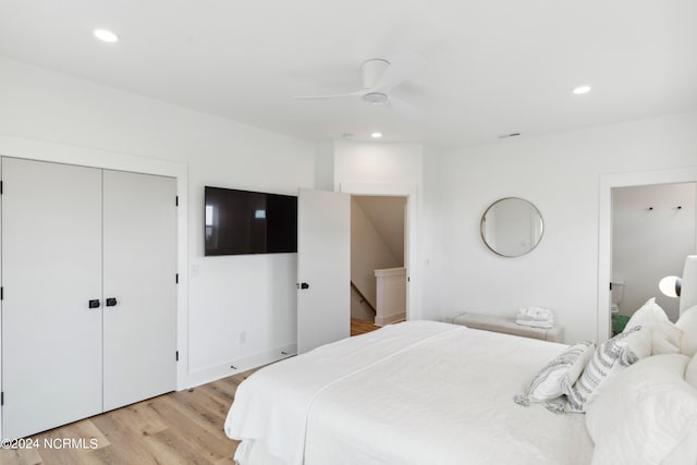 bedroom with ceiling fan, light wood-type flooring, and connected bathroom