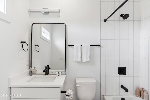 full bathroom featuring tiled shower / bath, vanity, and toilet