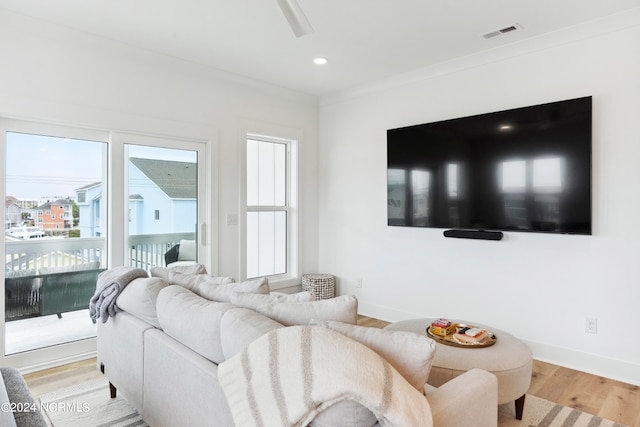 living room with hardwood / wood-style floors and crown molding