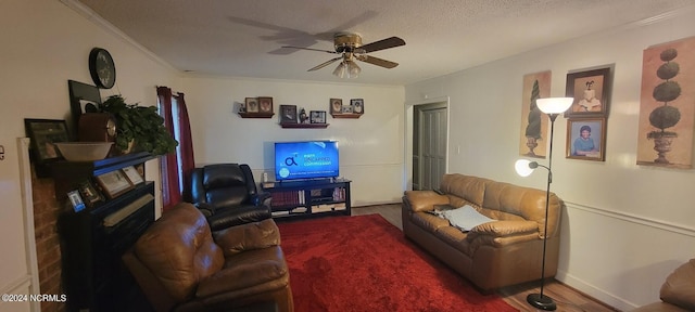 living room featuring crown molding, ceiling fan, and a textured ceiling