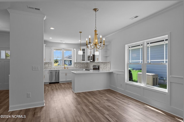 kitchen featuring white cabinetry, stainless steel appliances, decorative backsplash, hardwood / wood-style floors, and kitchen peninsula