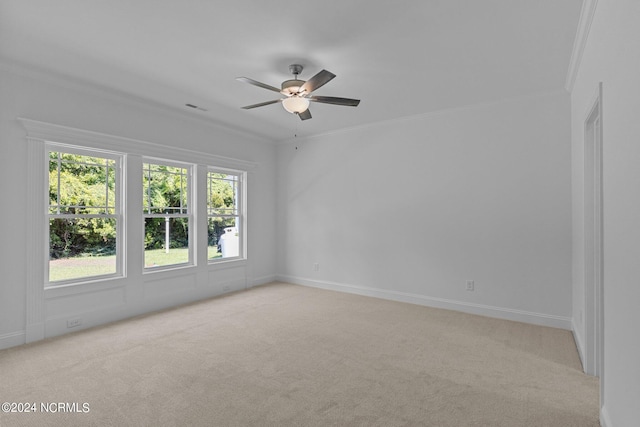 spare room featuring light carpet, ceiling fan, and crown molding