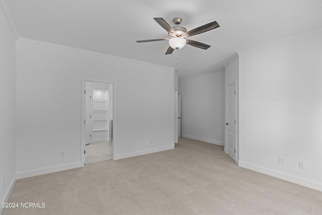 unfurnished bedroom with ensuite bathroom, light colored carpet, ornamental molding, and ceiling fan