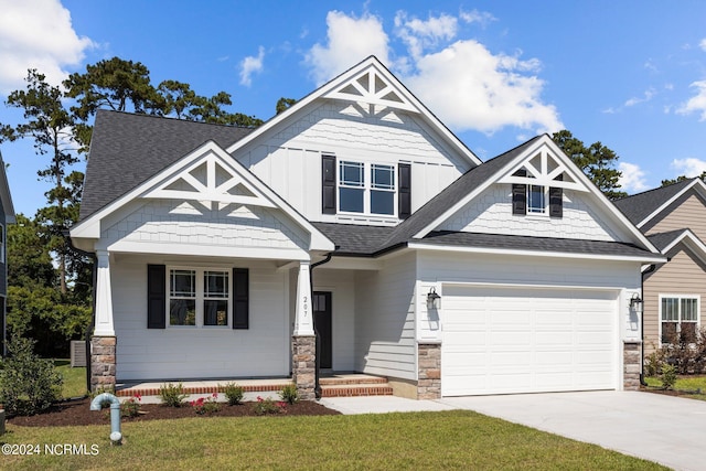 craftsman-style home featuring a garage, covered porch, and a front yard