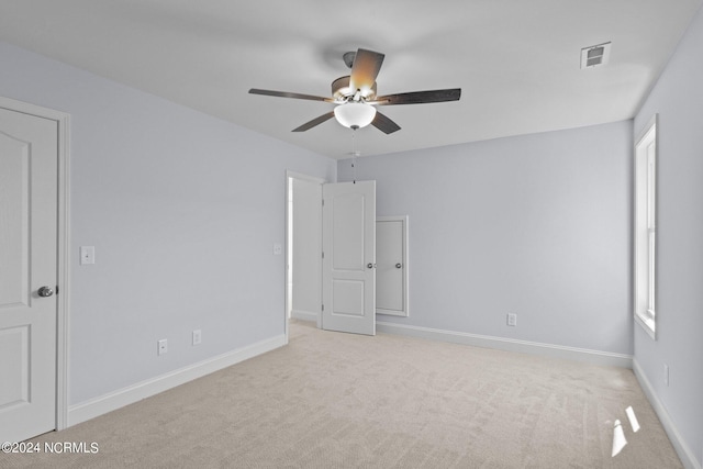 empty room with light colored carpet and ceiling fan