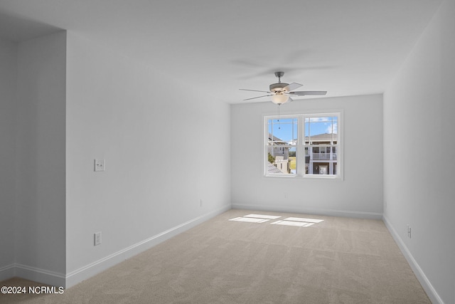 empty room featuring light colored carpet and ceiling fan