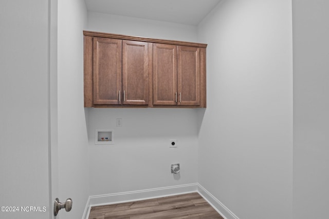 laundry area featuring hookup for a washing machine, hardwood / wood-style flooring, electric dryer hookup, and cabinets