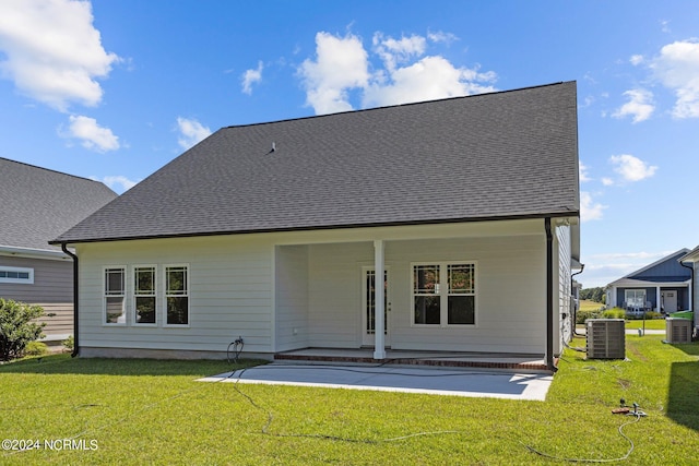 rear view of property with a patio, central AC unit, and a yard