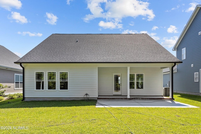 rear view of house with central AC unit, a patio, and a yard