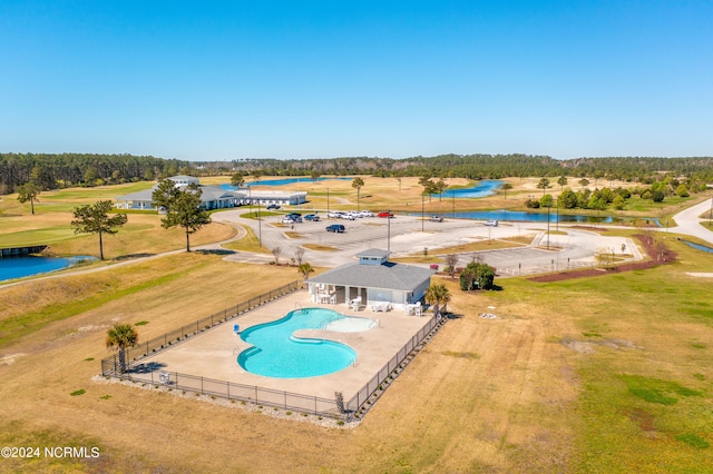 view of swimming pool with a water view, a patio, and a yard