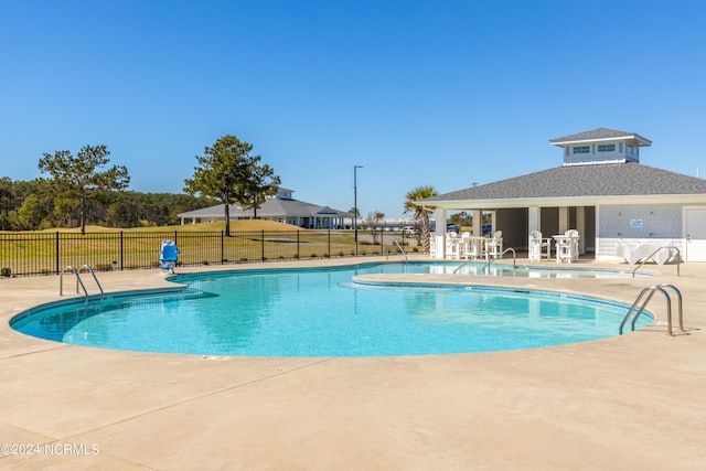 view of swimming pool with a patio and a yard