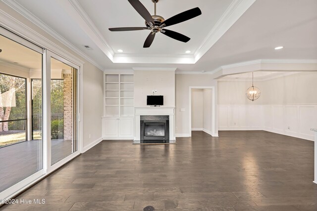 unfurnished living room with dark hardwood / wood-style floors, a healthy amount of sunlight, ornamental molding, and ceiling fan