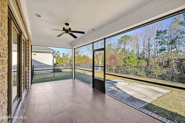 unfurnished sunroom featuring ceiling fan