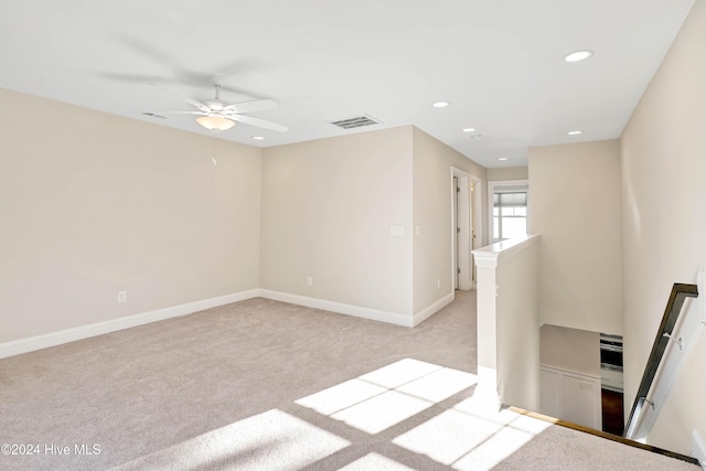 spare room featuring light colored carpet and ceiling fan