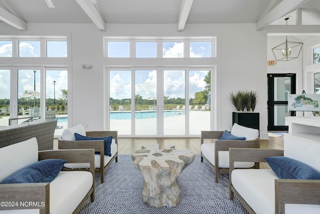 living room featuring a towering ceiling, beamed ceiling, and hardwood / wood-style flooring