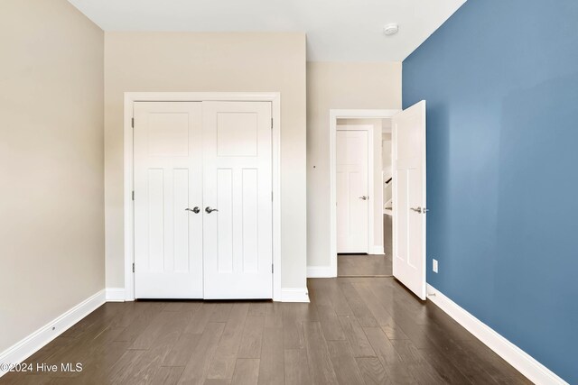 empty room with ceiling fan and dark hardwood / wood-style flooring