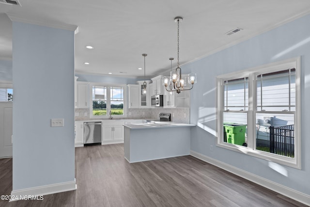 kitchen featuring kitchen peninsula, hardwood / wood-style flooring, white cabinets, and appliances with stainless steel finishes