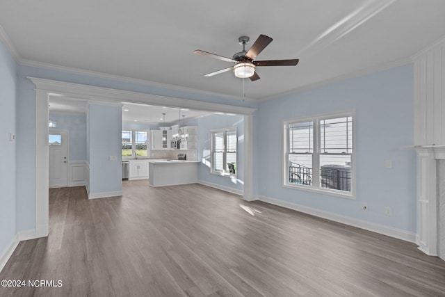 unfurnished living room with wood-type flooring, ceiling fan with notable chandelier, and ornamental molding