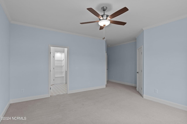 carpeted empty room featuring ceiling fan and crown molding