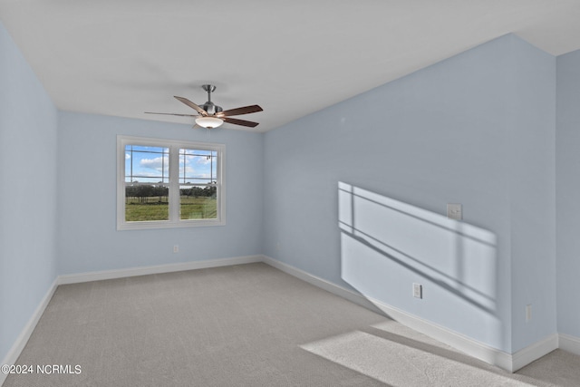 empty room featuring light colored carpet and ceiling fan