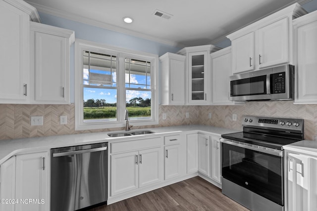 kitchen with white cabinets, sink, ornamental molding, and stainless steel appliances