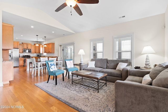 living room featuring vaulted ceiling, ceiling fan, and light wood-type flooring