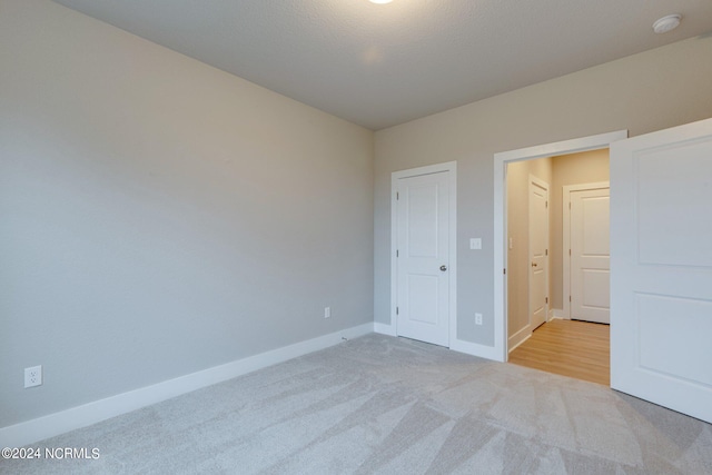 unfurnished bedroom featuring light carpet