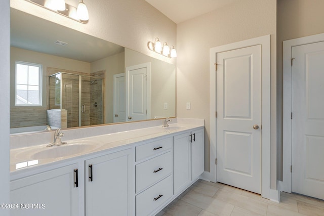 bathroom with dual sinks, tile floors, separate shower and tub, and vanity with extensive cabinet space