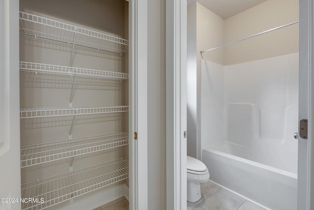 bathroom with toilet, tile flooring, and shower / bathtub combination