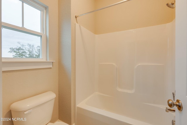 bathroom with bathtub / shower combination and toilet