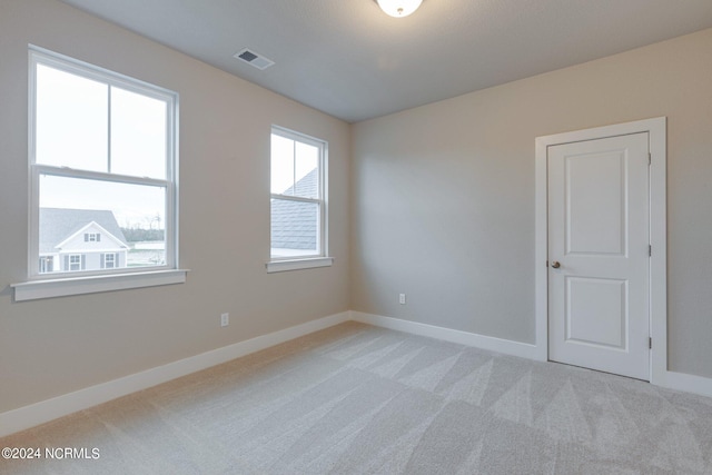 empty room with a healthy amount of sunlight and carpet floors