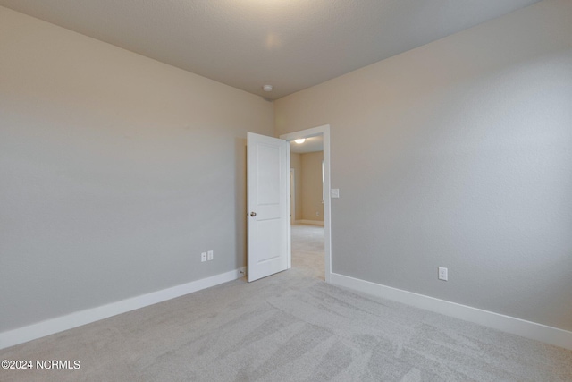 unfurnished room with light colored carpet