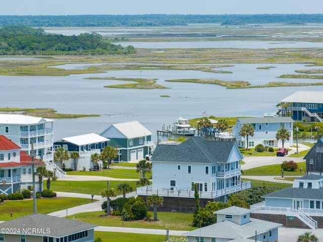 exterior space featuring a front yard, a balcony, a garage, a water view, and a porch