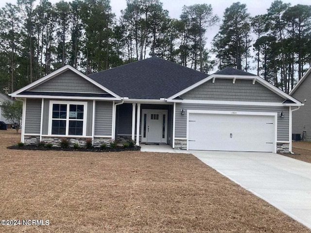 craftsman inspired home featuring a front lawn and a garage