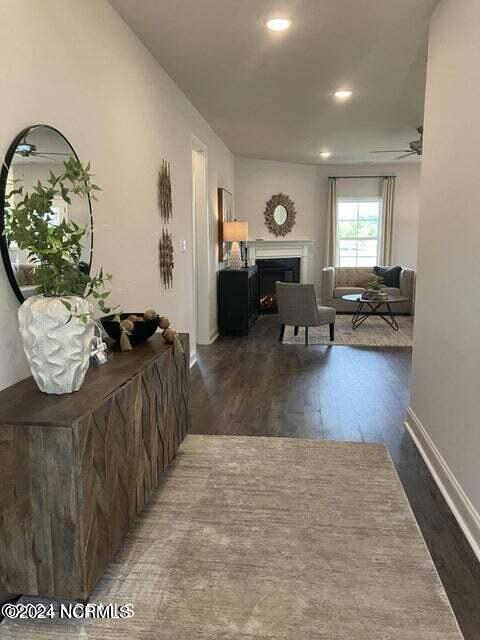 living room featuring ceiling fan, dark wood-type flooring, and a wealth of natural light