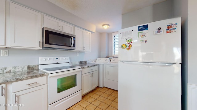 kitchen with separate washer and dryer, white cabinetry, light tile patterned floors, and white appliances