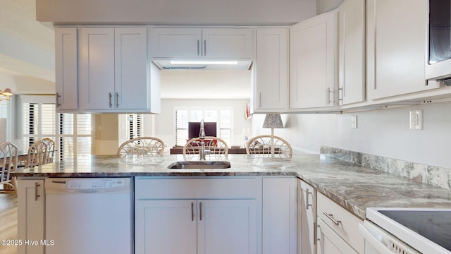 kitchen with kitchen peninsula, light stone counters, sink, dishwasher, and white cabinetry