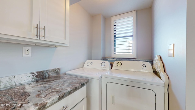 clothes washing area with washer and dryer and cabinets